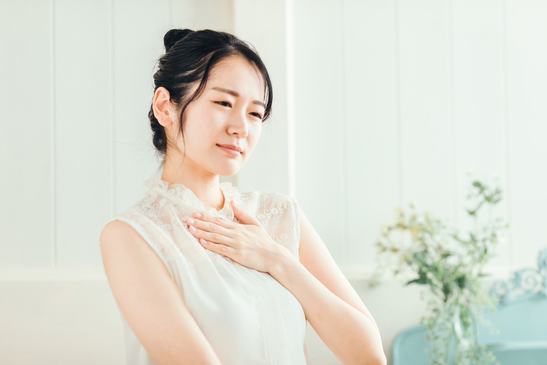 胸の上を押さえる女性