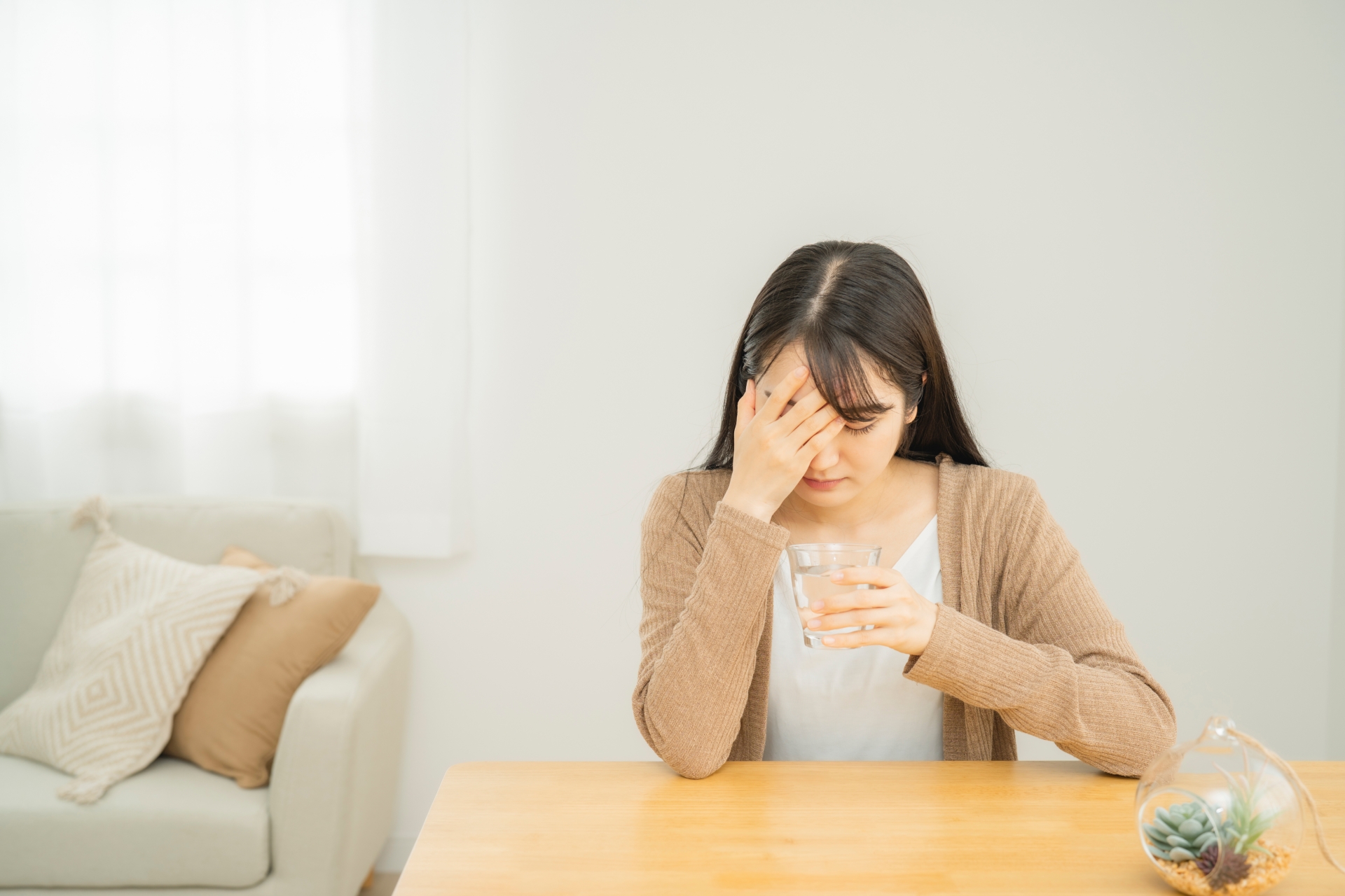 頭を押さえる女性