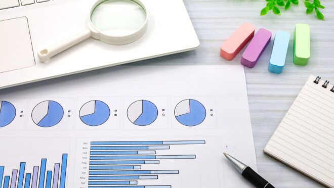 円グラフと棒グラフの書かれた紙が机に置かれている様子