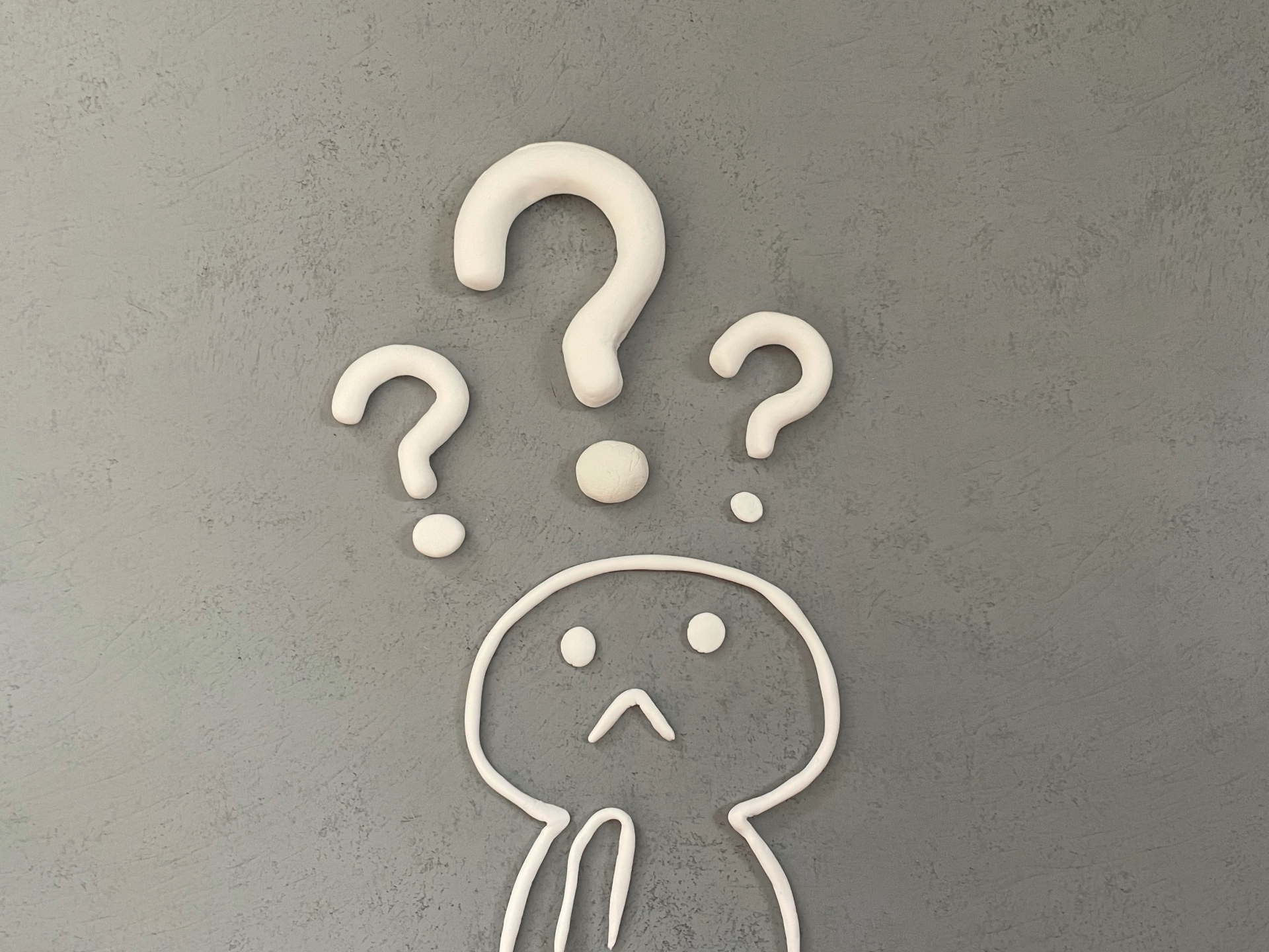 粘土で作ったイラスト。人の上に疑問符マークが浮かんでいる