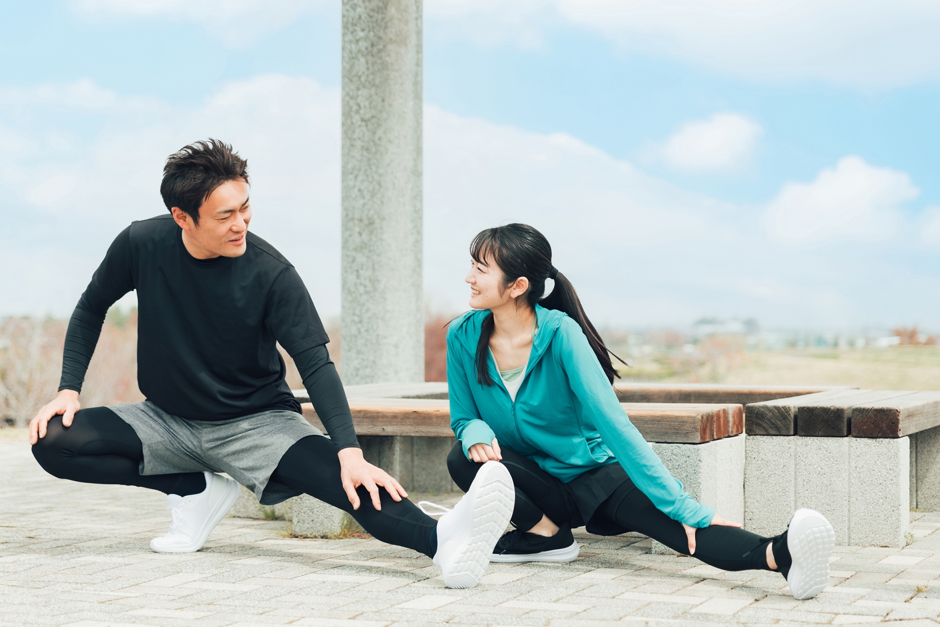 公園でストレッチを行う男女