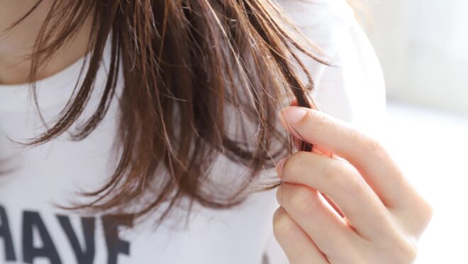 自分の髪を触る女性