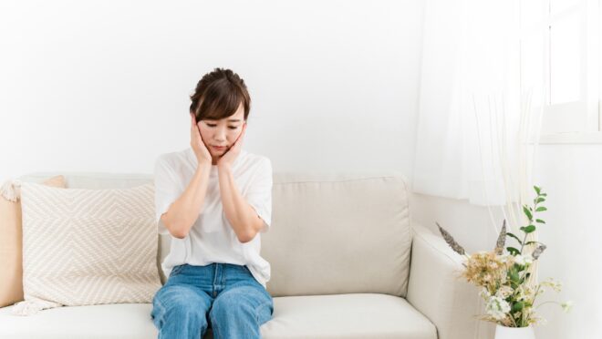 ソファで思い悩む女性