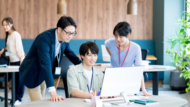 オフィスで話し合う3人の会社員