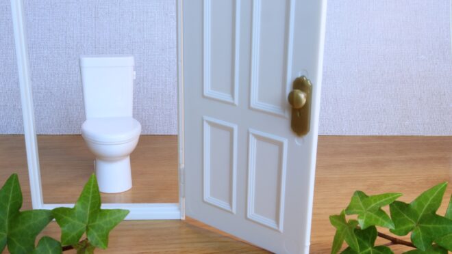 トイレのミニチュアの前にドアのミニチュアが置かれている様子