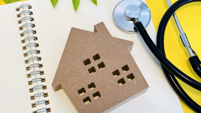 家の形のブロックと聴診器が置かれている様子
