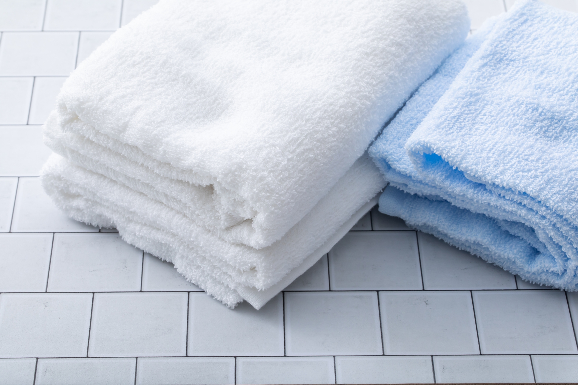 畳まれた白いタオルと水色のタオル