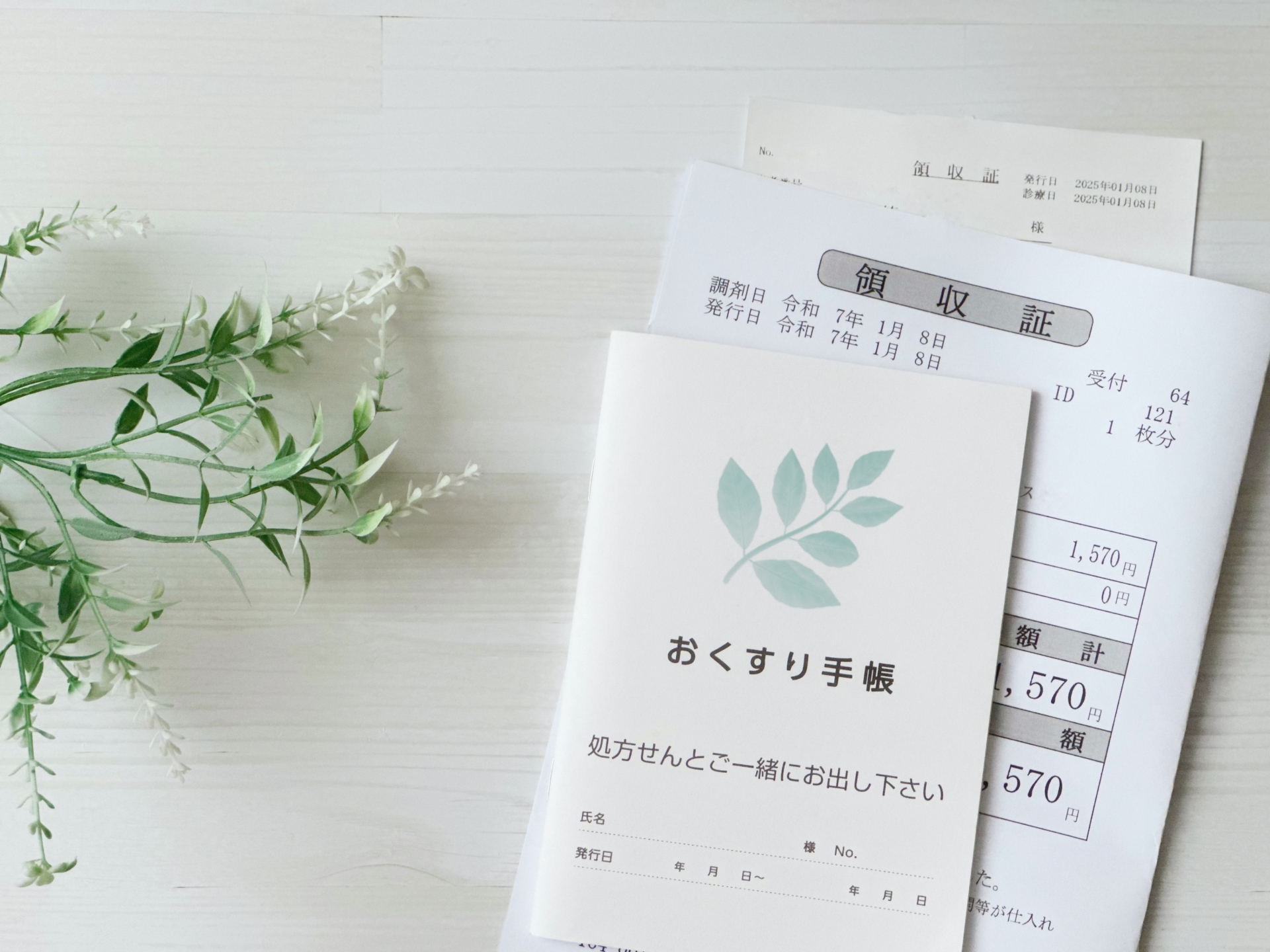 机の上におくすり手帳と領収書が置かれている様子