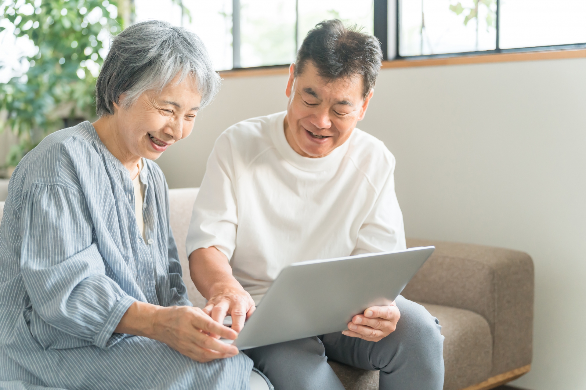 タブレットを操作する高齢夫婦