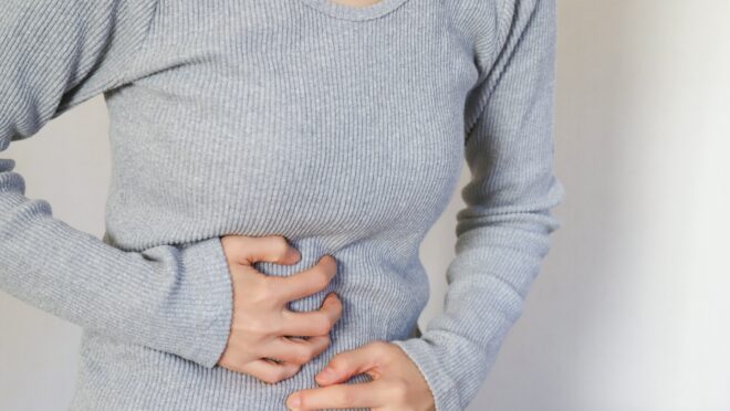 腹部を押さえる女性