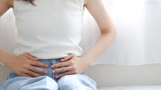 下腹部を押さえる女性