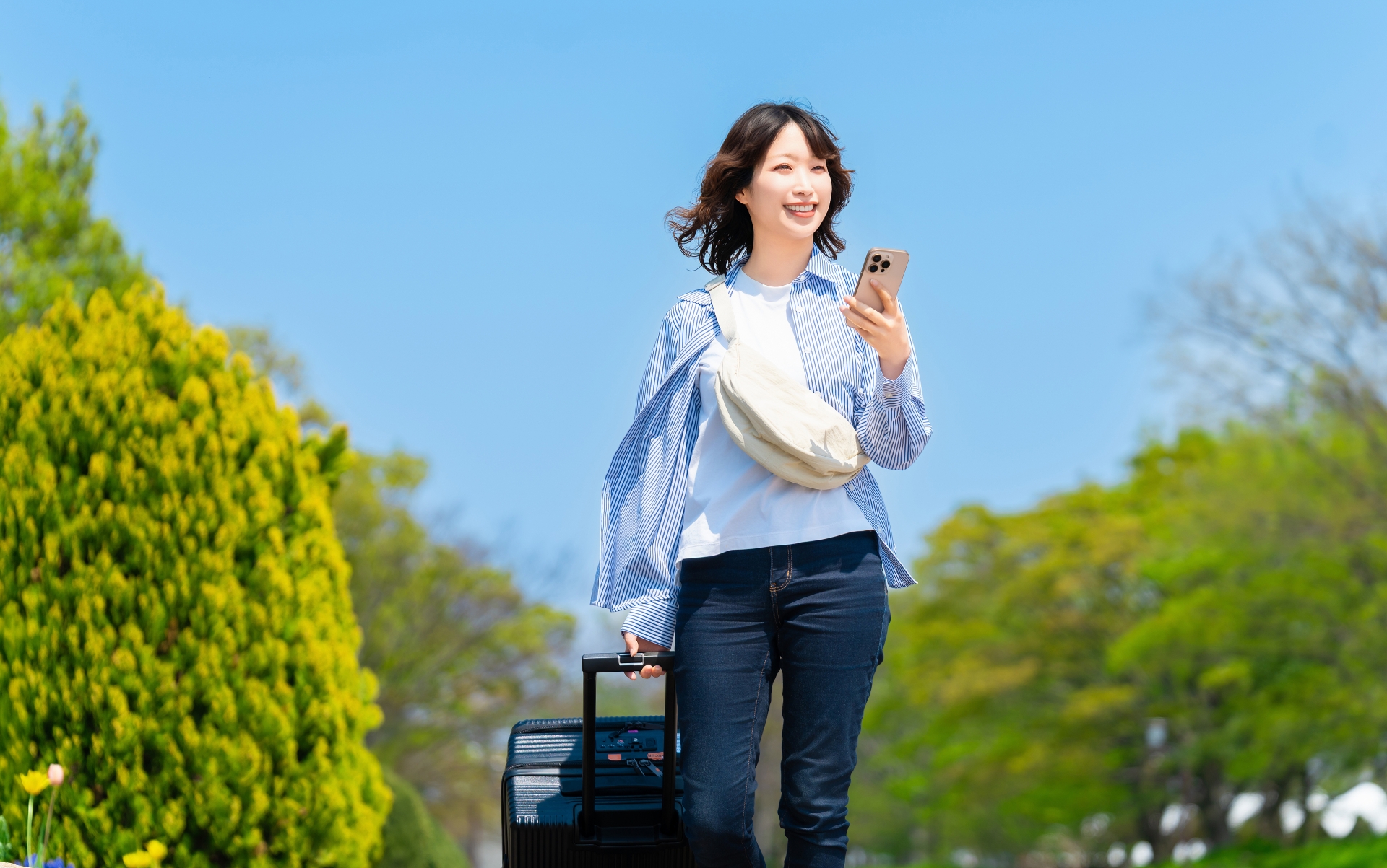 スーツケースを手に歩く女性