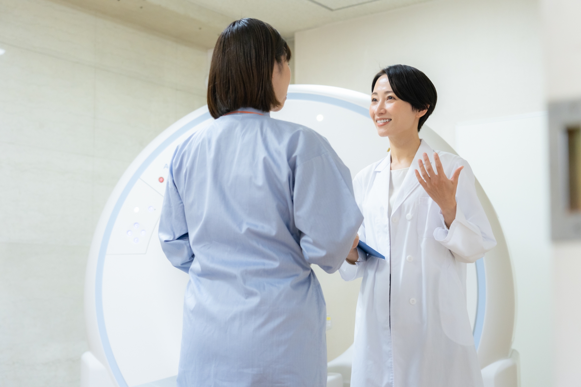 CT機器の前で患者に説明する医師