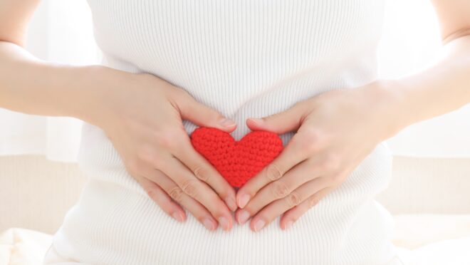 お腹に手を当てる女性