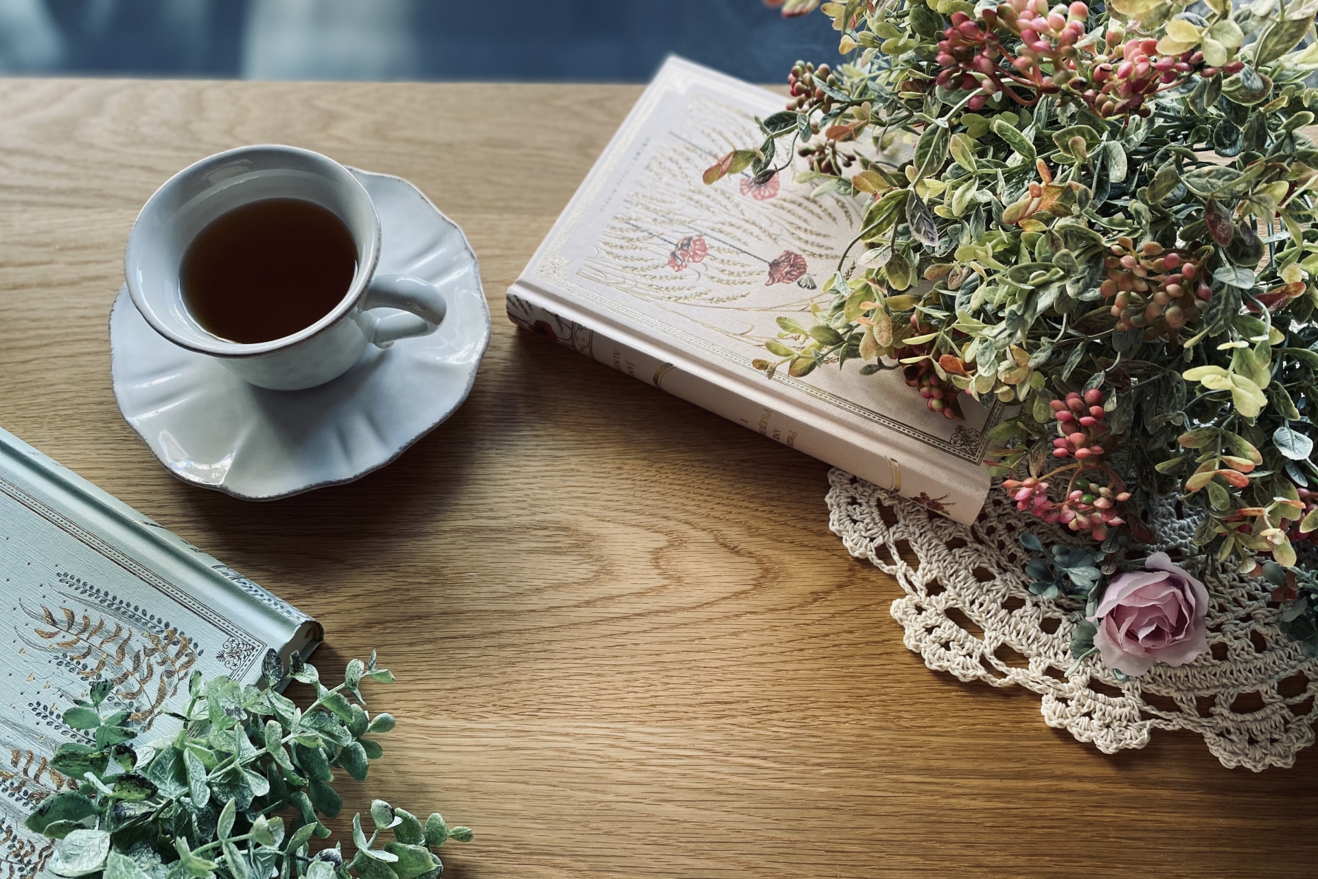 机に置かれたコーヒーカップと本