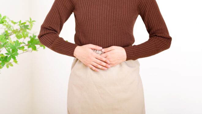 腹部を押さえる女性