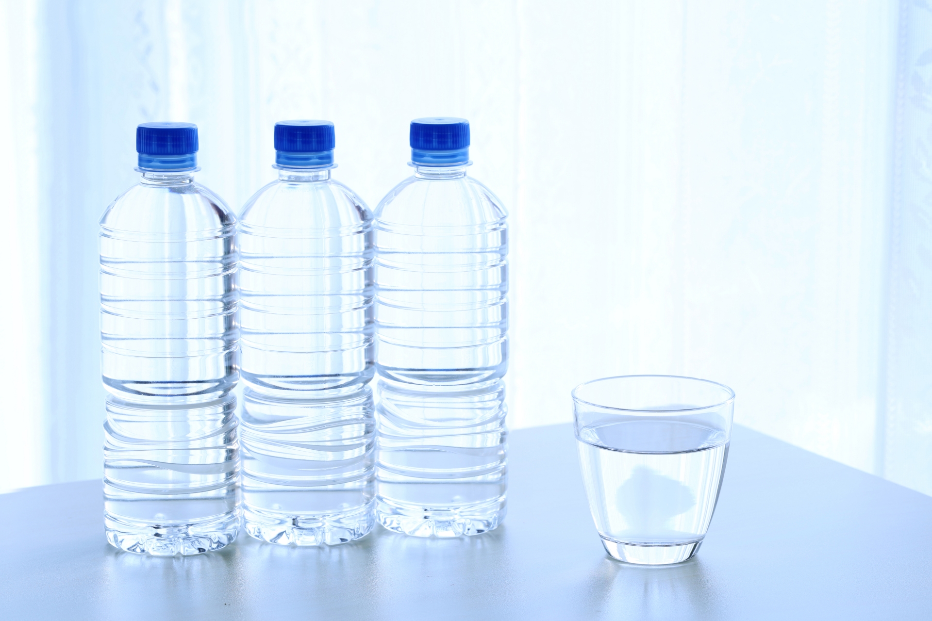 テーブルに置かれたペットボトルの水とグラス