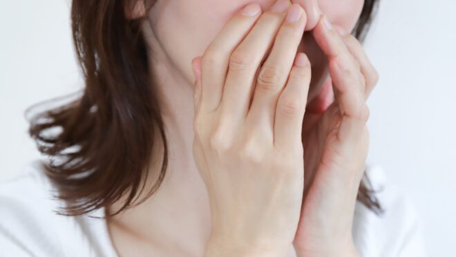 鼻を押さえる女性