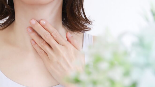 喉を押さえる女性