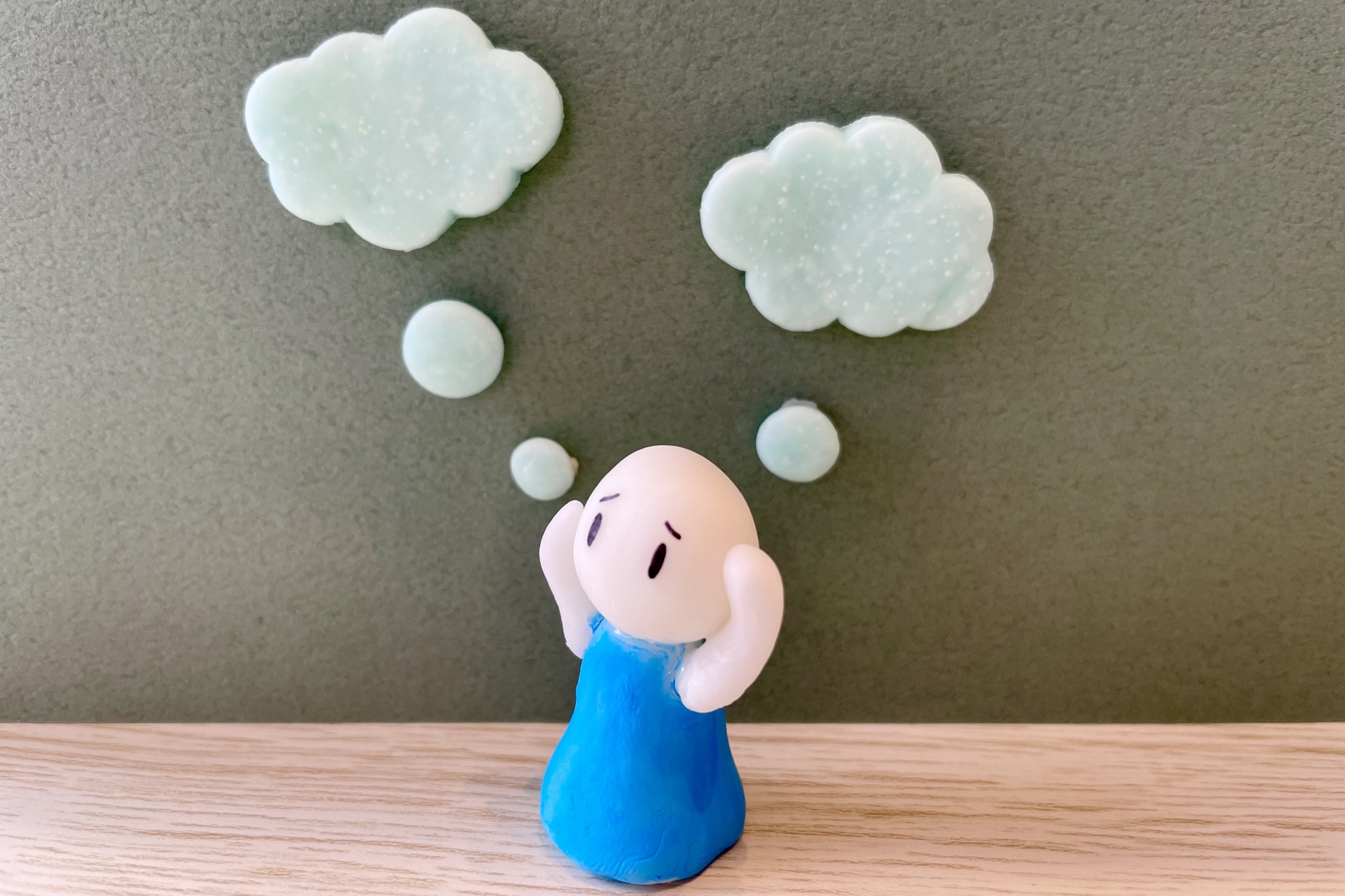 困った表情で悩む人を現した人形