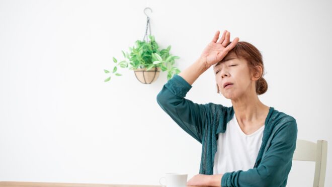 頭を押さえる女性