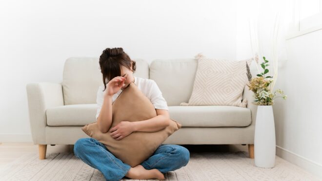 床に座り悩む女性