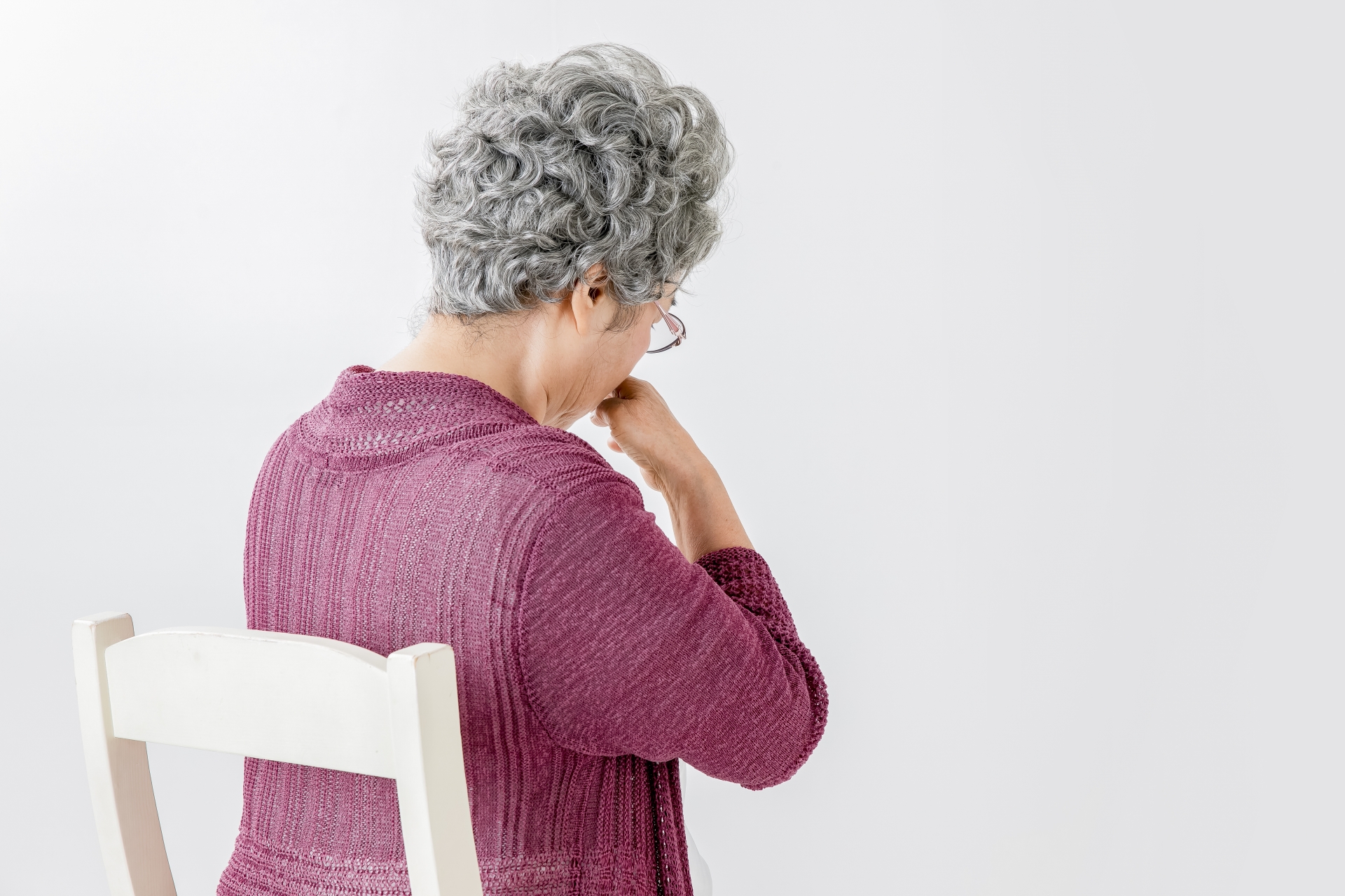 鼻を押さえる高齢の女性