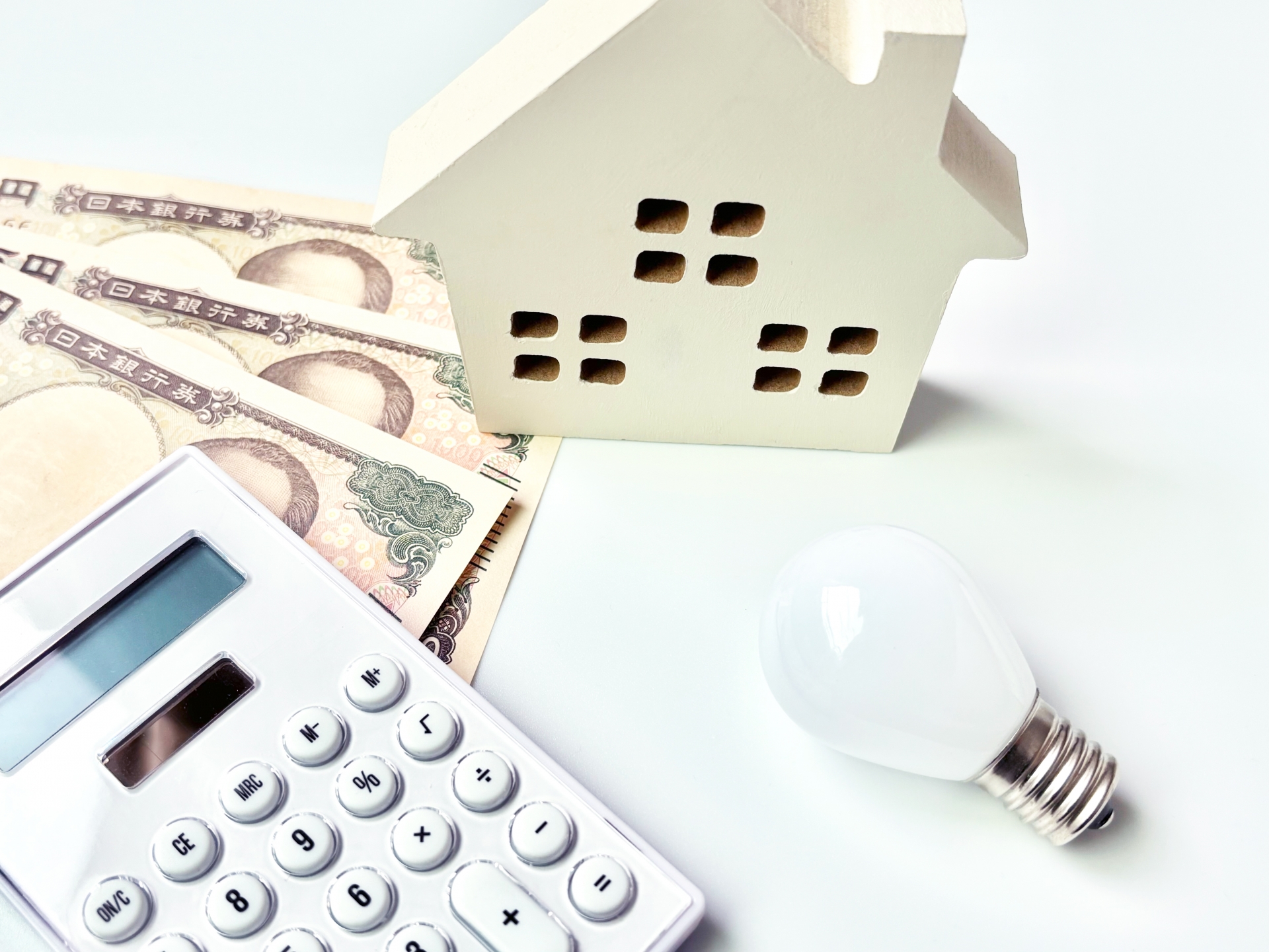 家の形のブロックと紙幣と電卓