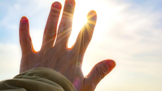 太陽に手をかざしている様子