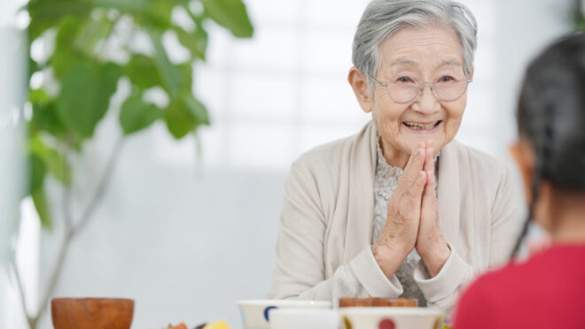 食事前に手を合わせる女性