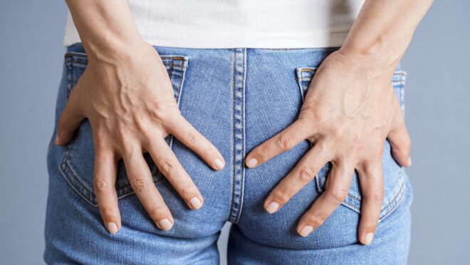 お尻を押さえる女性