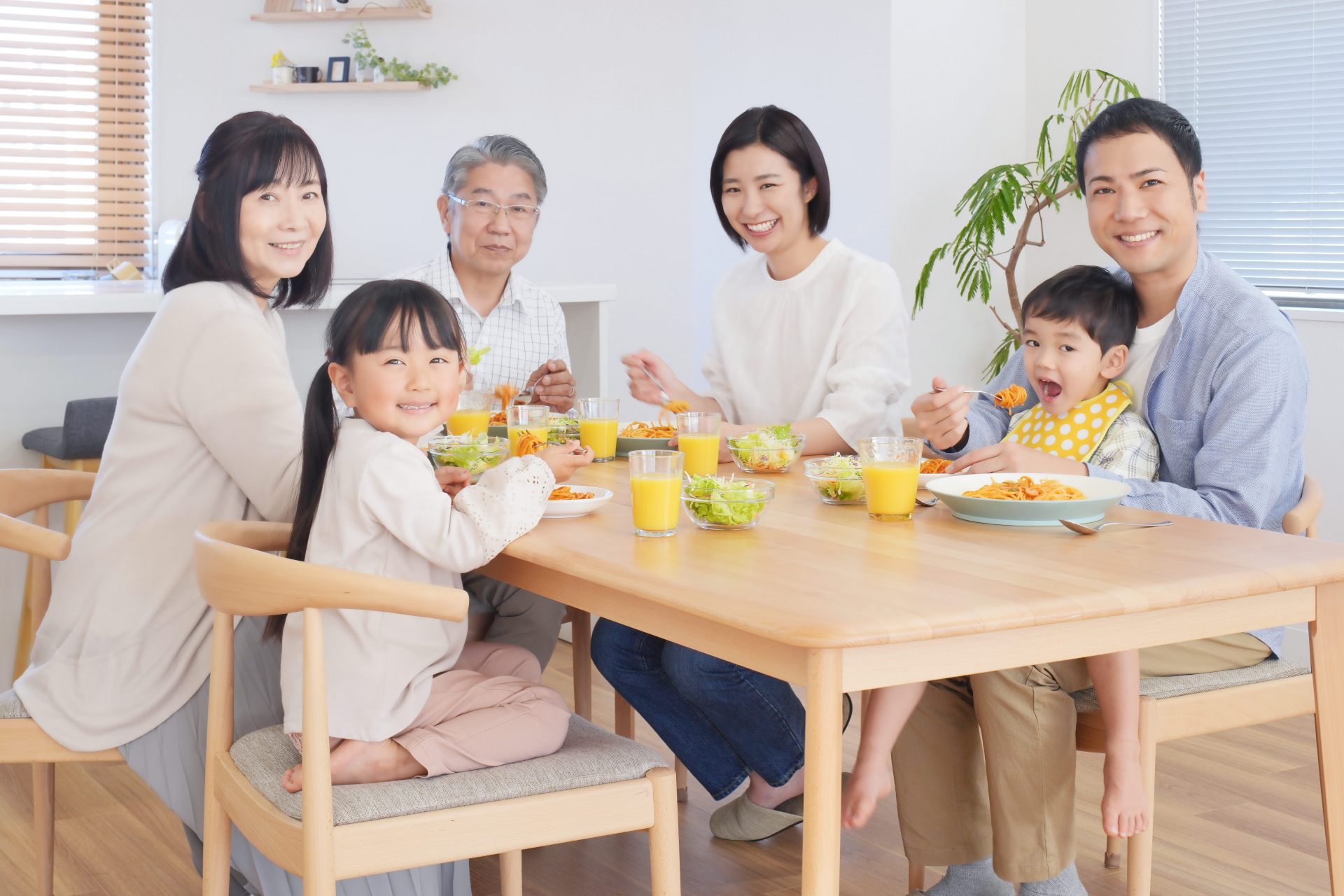 三世代親子がリビングで食事を摂る様子