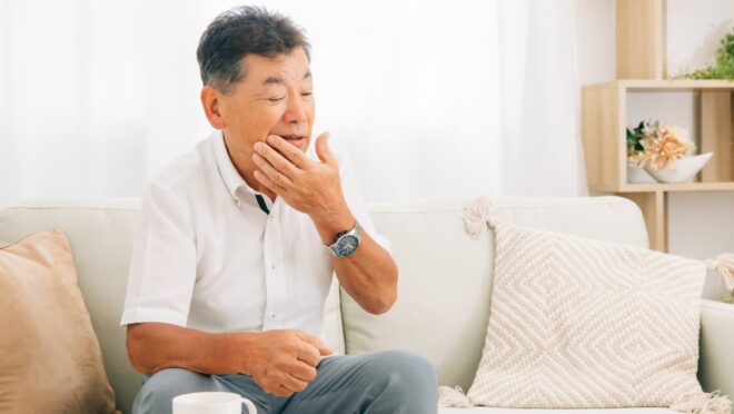 口元を押さえる男性