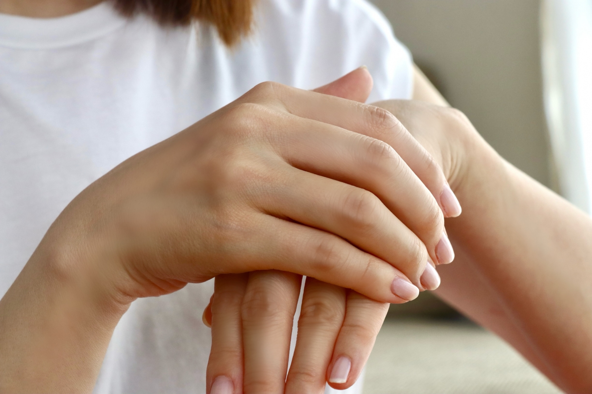 手の甲を押さえる女性