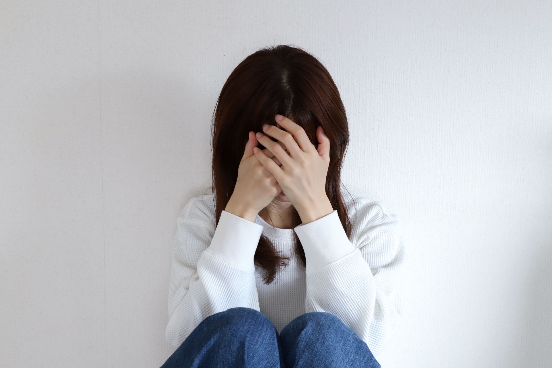 頭を抱え落ち込む女性