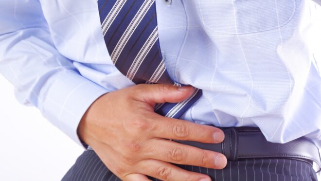 お腹を押さえる男性