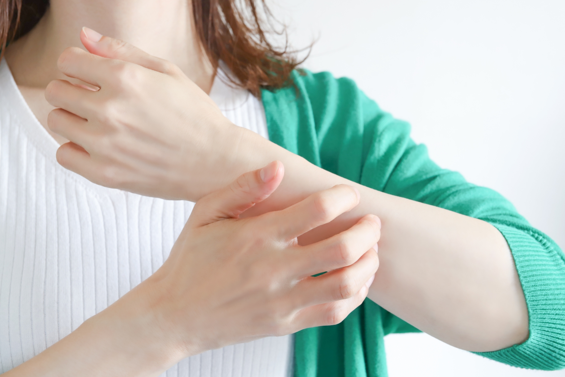 腕をかく女性