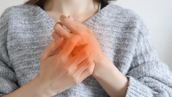 赤くなった手を押さえる女性