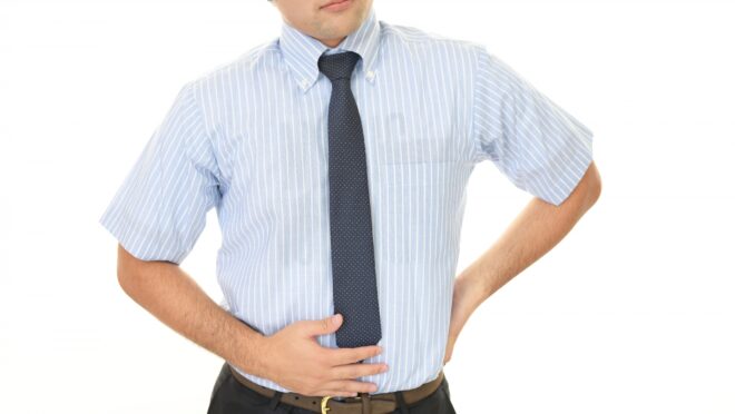 右脇腹を押さえる男性