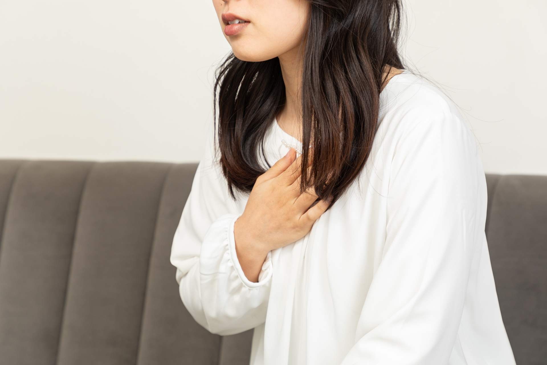 胸を押さえる女性