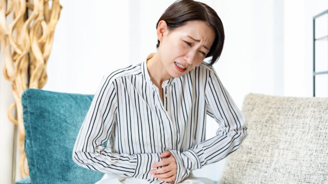 腹部を押さえる女性