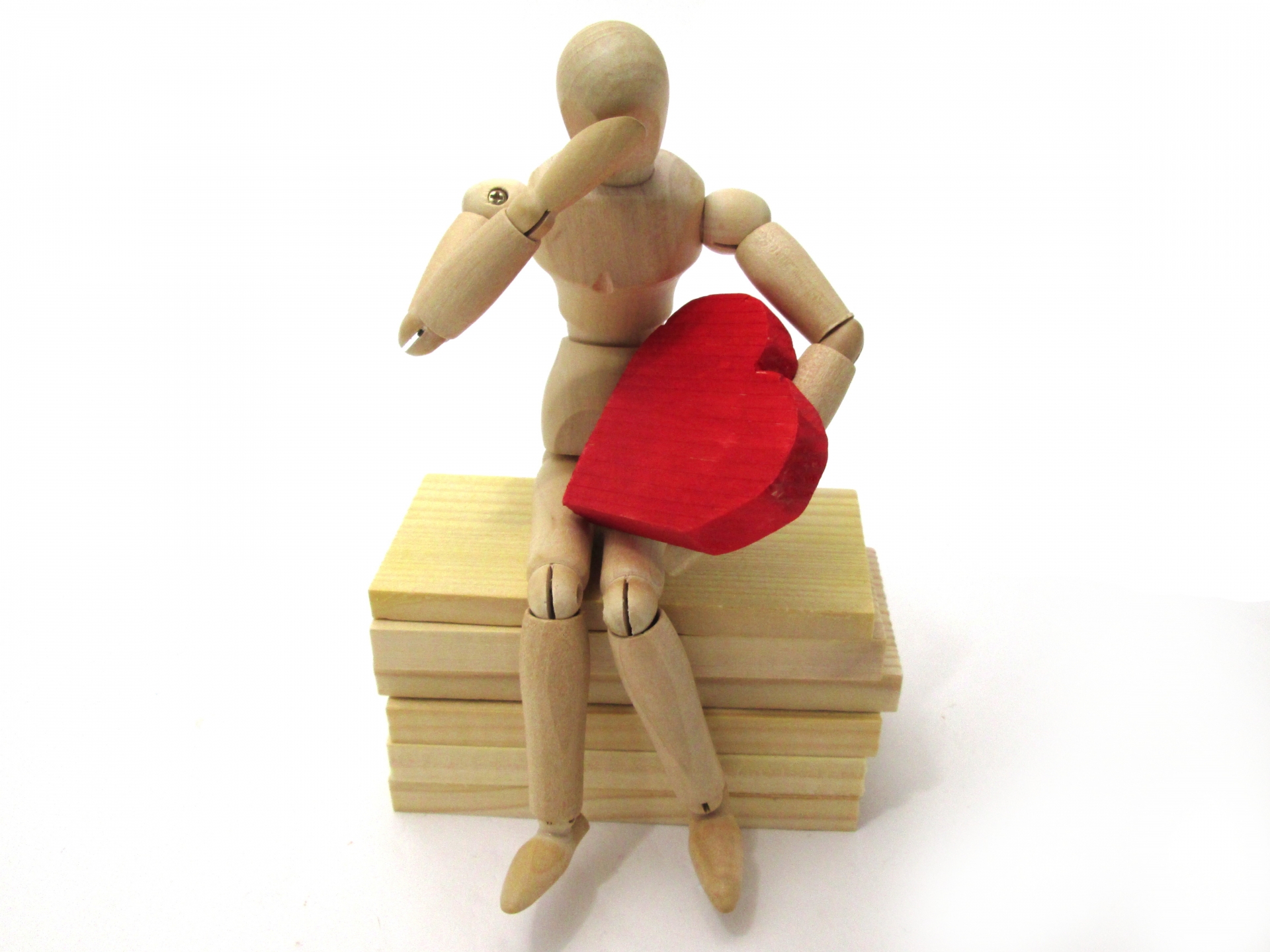 ハートを抱えて落ち込むデッサン人形