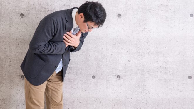 胸を押さえる男性