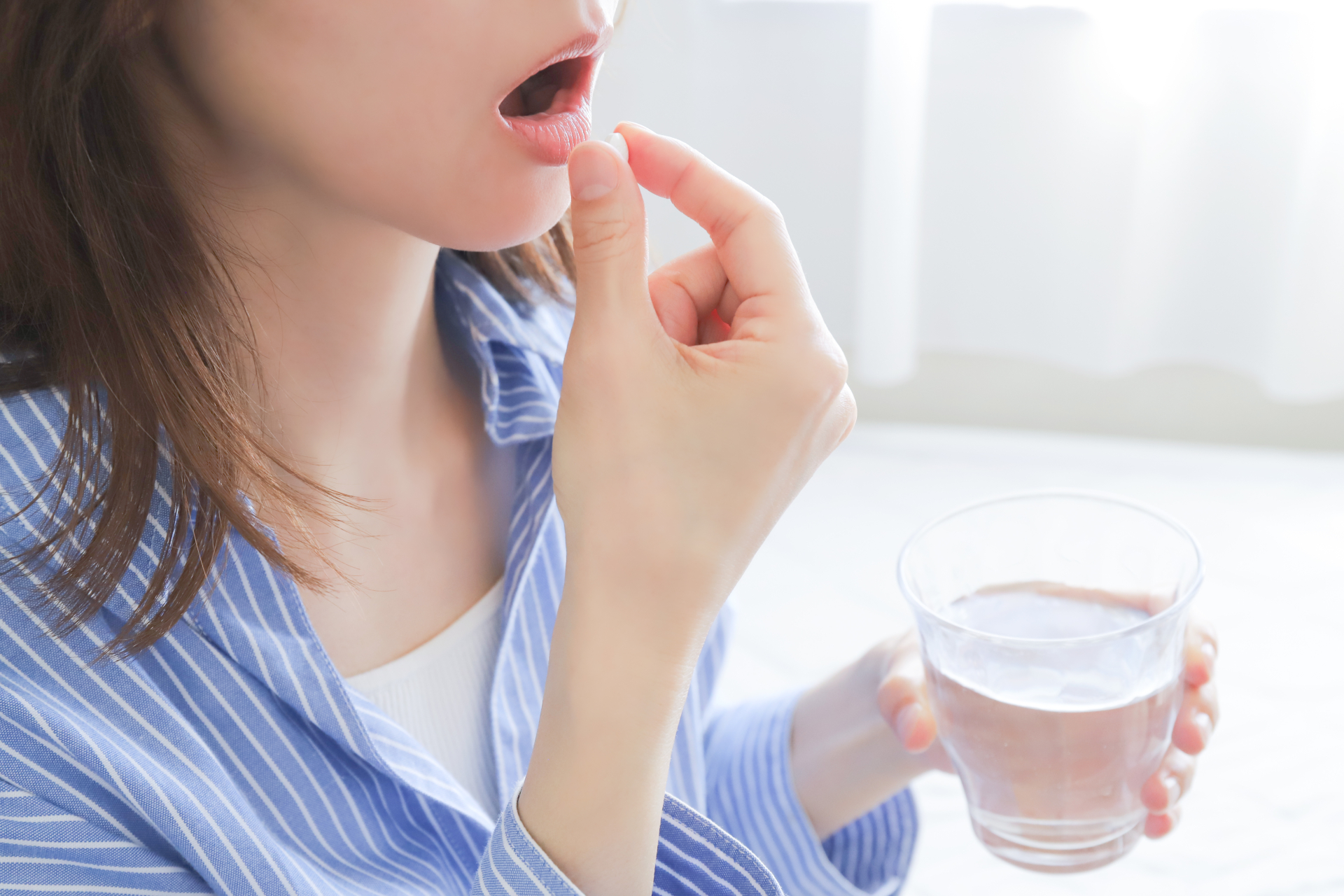 薬を服用する女性