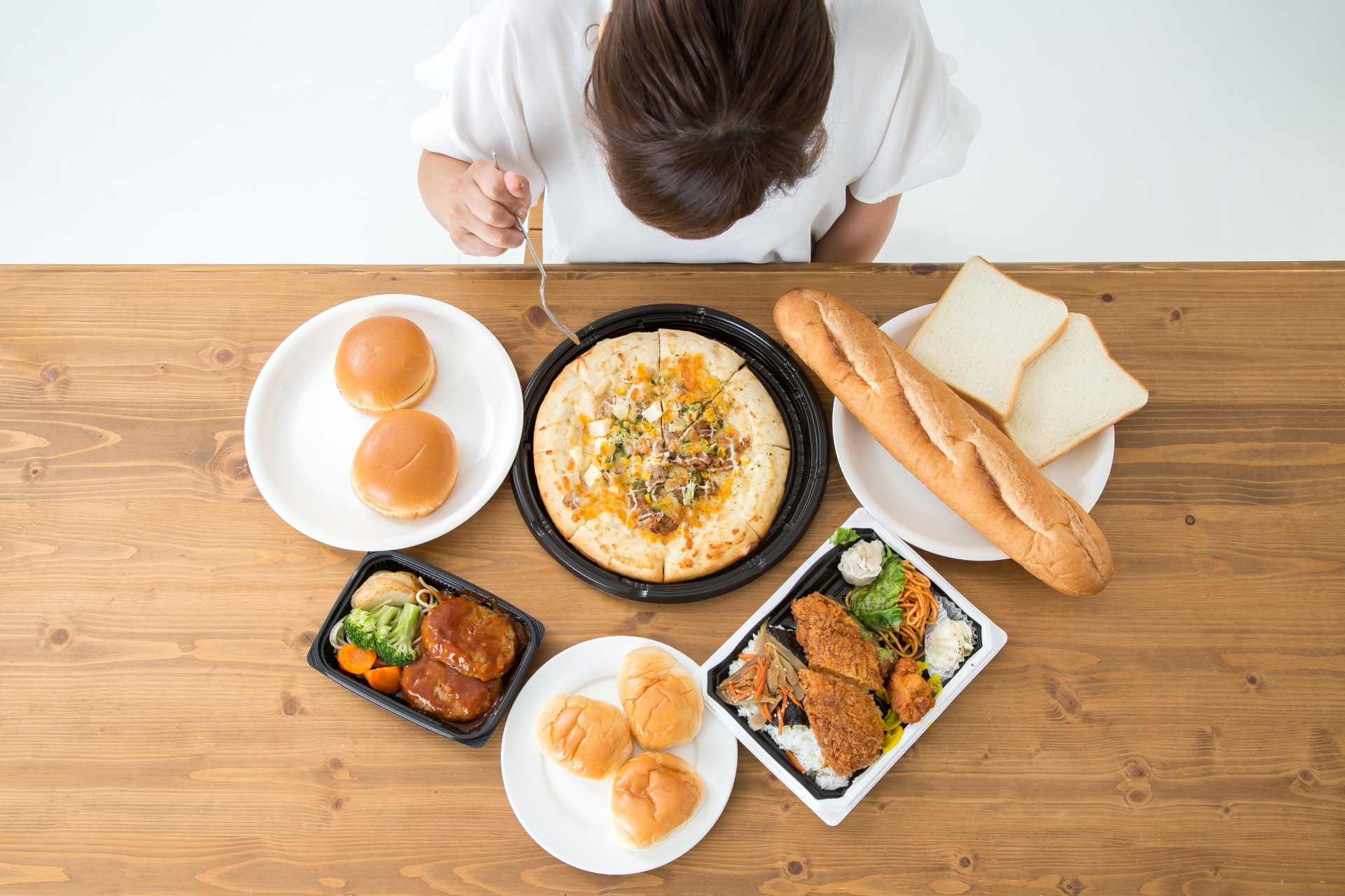 高カロリー・高脂肪食品が机の上に並んでいる様子