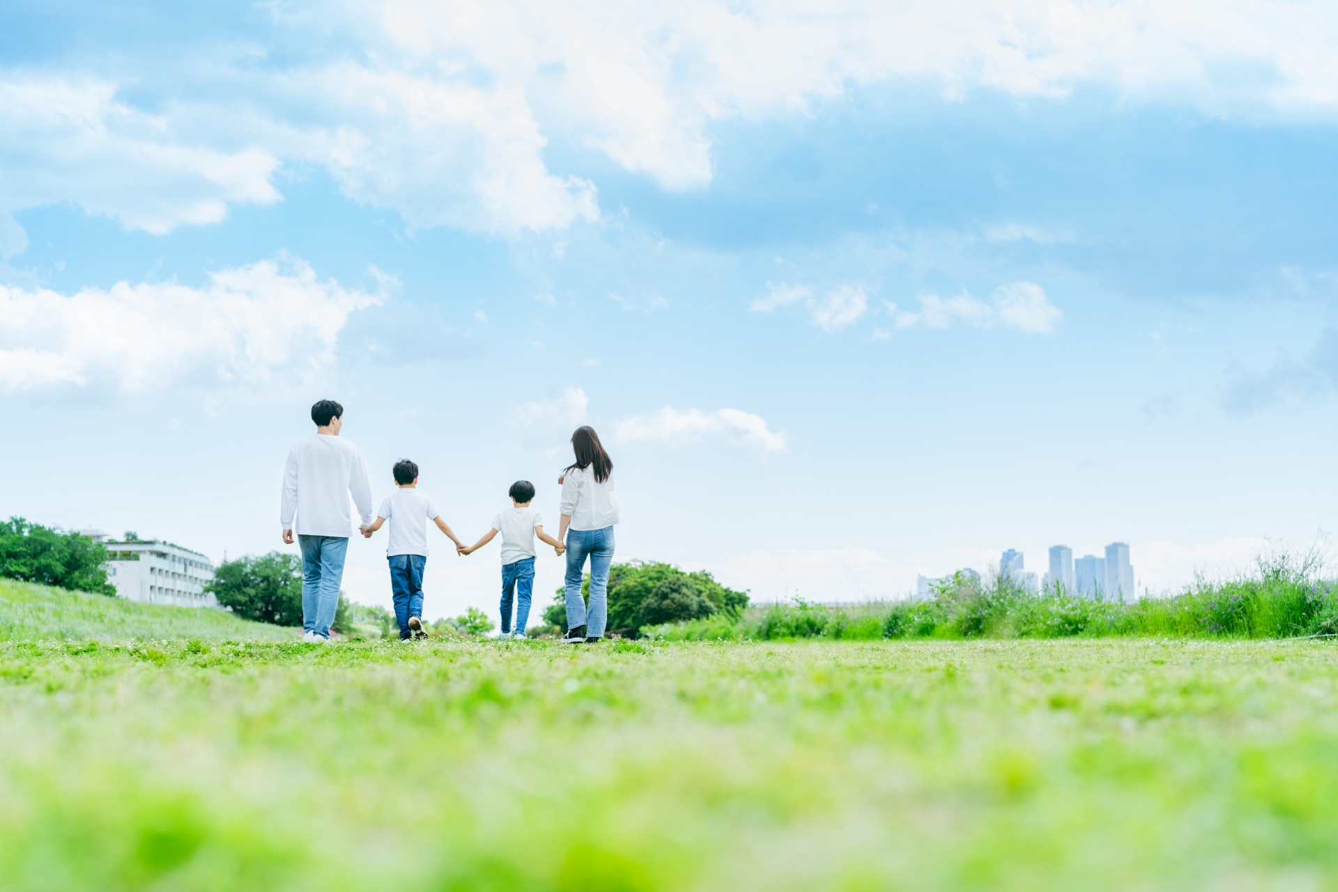 広場を歩く四人家族