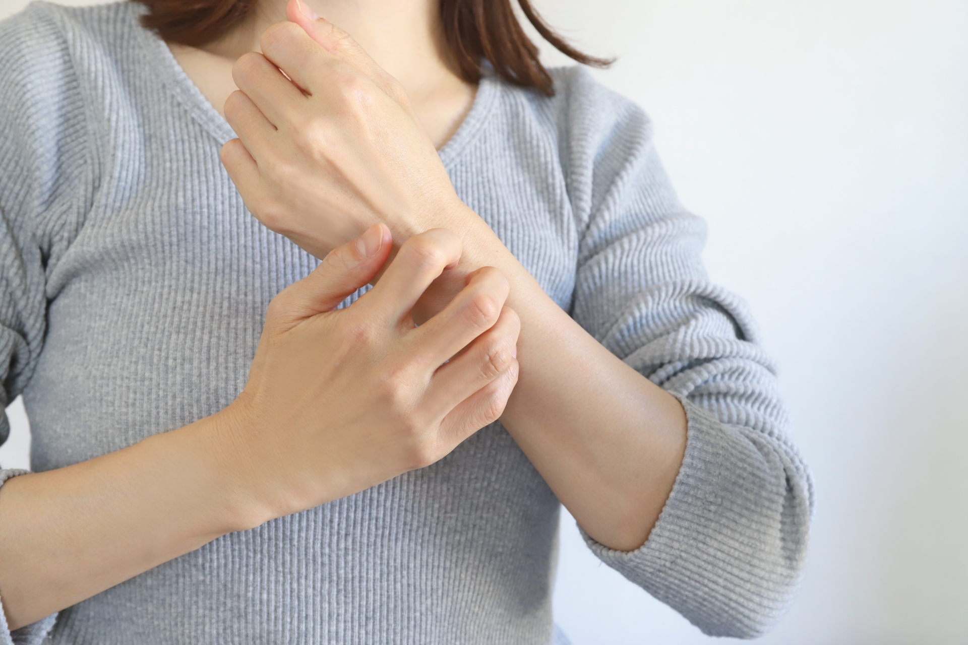 手のかゆみを覚える女性
