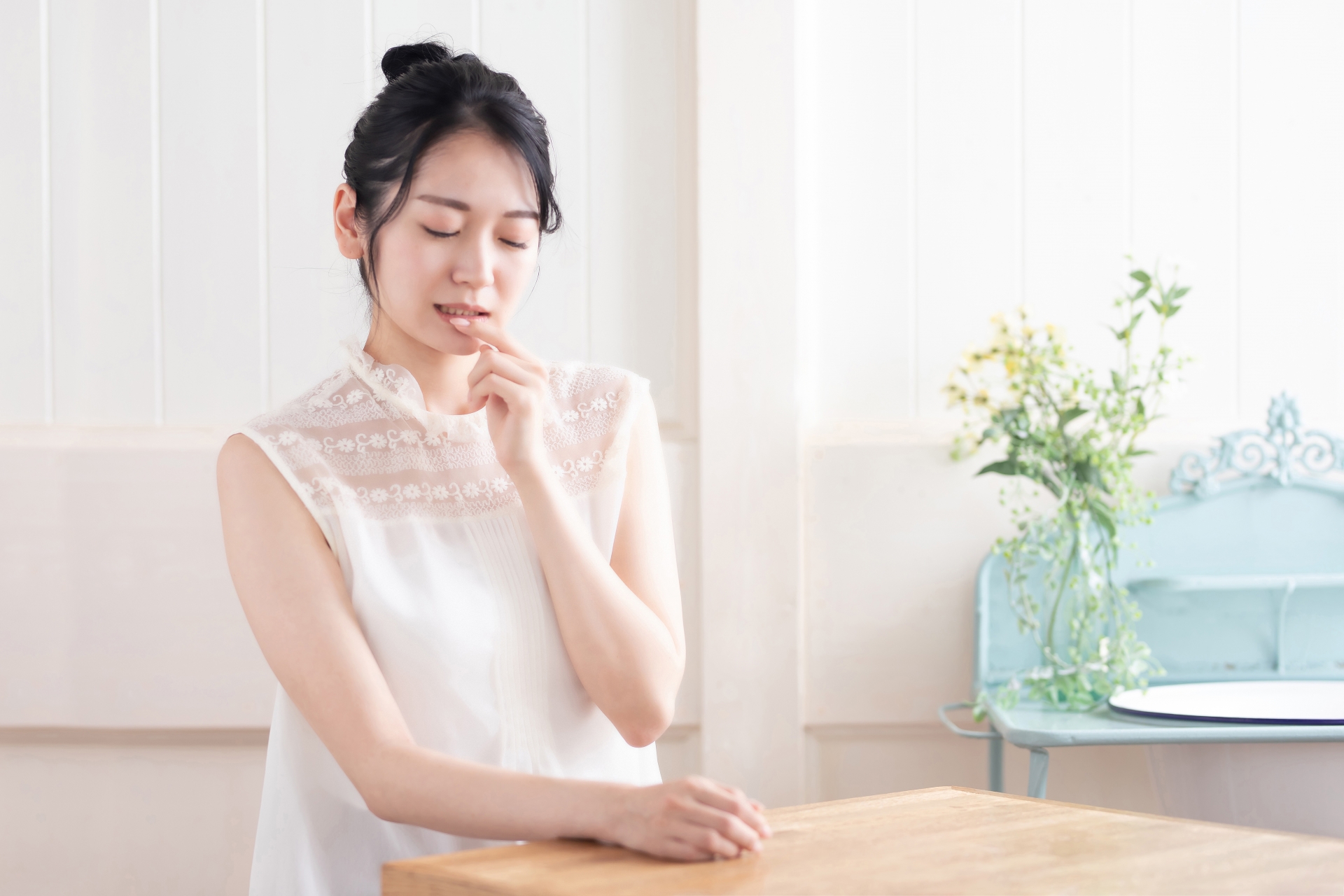 自分の唇に触れる女性