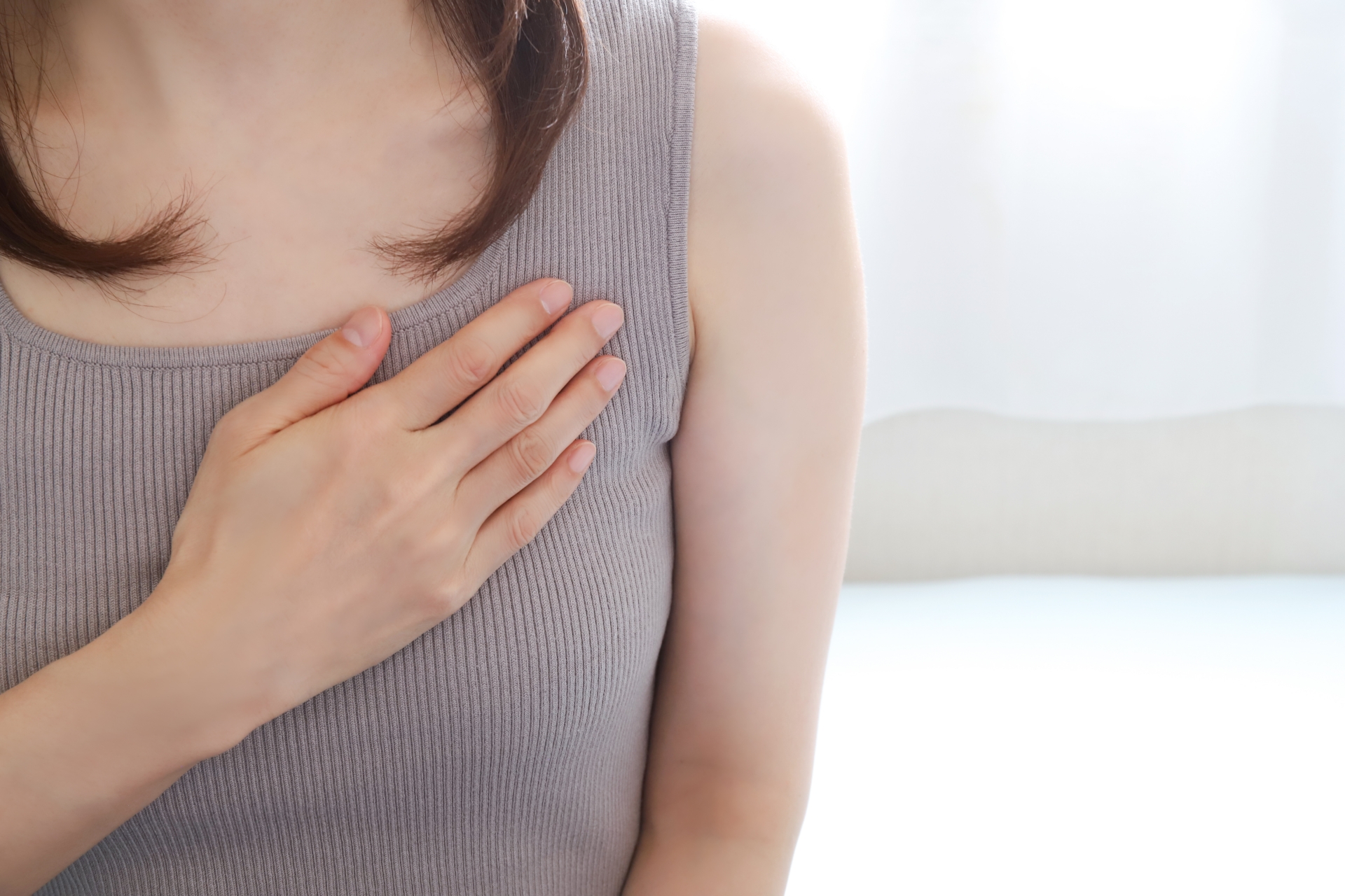 胸を押さえる女性
